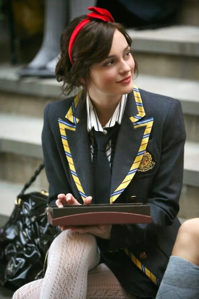 Her homage to red continues, with a bright red bow, school blazer, oversized tie, striped shirt and white knitted stockings.